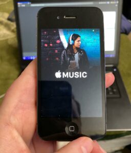 A photo of an iPhone 4 stuck at the Apple Music ad screen